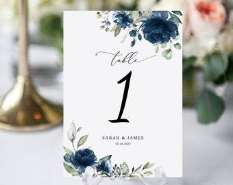 May include: White wedding table number card with blue watercolor floral design. The card says "Table 1" and "Sarah & James 10.14.2022".