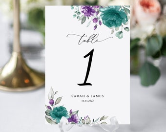 May include: Table number one with teal and purple floral design. The text reads "table 1" and "Sarah & James 10.14.2022".