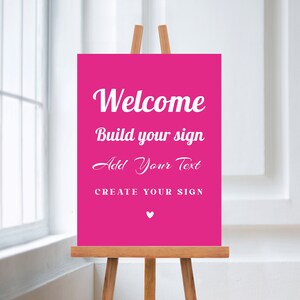 May include: A pink welcome sign with white text that reads "Welcome, Build your sign, Add Your Text, CREATE YOUR SIGN". A small white heart is at the bottom of the sign.