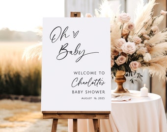 Pode incluir: Um cartaz branco com caligrafia preta que diz "Oh Baby" com um símbolo de coração. O cartaz também diz "Bem-vindo ao Chuveiro de Bebê da Charlotte em 16 de agosto de 2025".