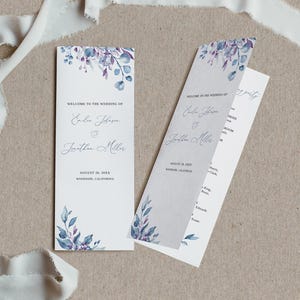 Könnte beinhalten: Zwei hohe, rechteckige Hochzeitskarten mit weißem Hintergrund und Aquarellillustrationen von violetten und blauen Blättern oben und unten. Der Text lautet Welcome to the wedding of Emilee Johnson and Jonathan Miller.