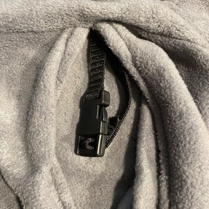 Peut inclure: Sweat-shirt &agrave; capuche en polaire gris avec un cordon de serrage noir et un bouton en plastique noir. Le sweat-shirt a le mot "KIRSA" brod&eacute; sur le devant.