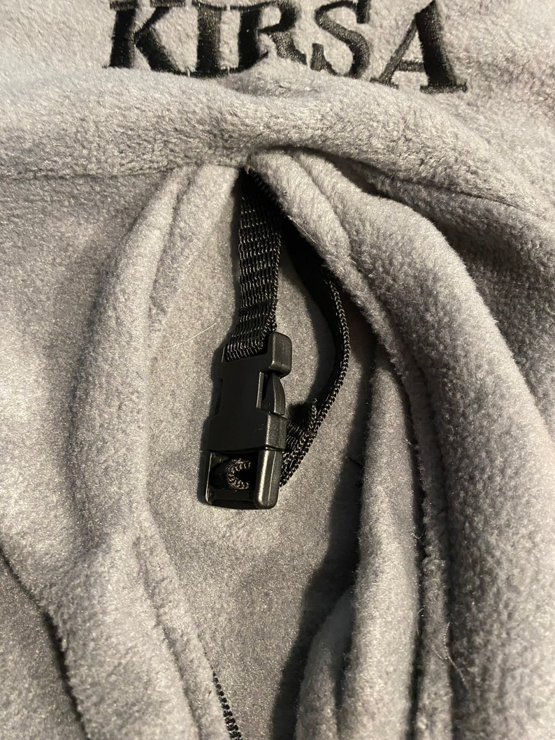 Peut inclure: Sweat-shirt &agrave; capuche en polaire gris avec un cordon de serrage noir et un bouton en plastique noir. Le sweat-shirt a le mot "KIRSA" brod&eacute; sur le devant.