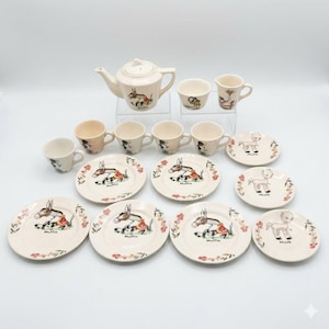 May include: A ceramic children's tea set in cream with colorful illustrations of a donkey named Muffin and a small horse. The set includes a teapot, a creamer, five cups, and seven saucers, all decorated with floral accents and character art.