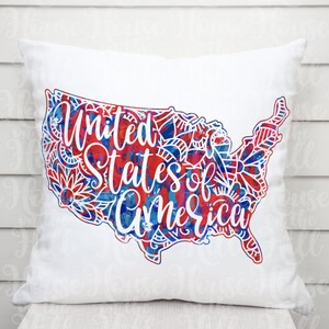 Könnte beinhalten: Ein weißes Kissen mit einem roten, weißen und blauen Aquarelldesign der Vereinigten Staaten. Das Design enthält die Worte "United States of America".