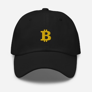 Puede incluir: Una gorra de béisbol negra con un símbolo de Bitcoin bordado en oro.