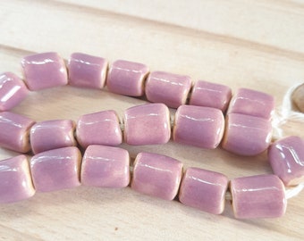 Perle cilindriche in ceramica viola per macramè e gioielli. Il numero di perle del tubo è di 20 pezzi su una corda.