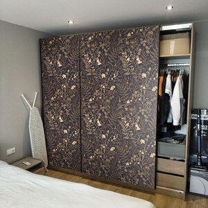May include: A white closet door with a floral pattern in gold. The closet door is made of wood and has a modern design.