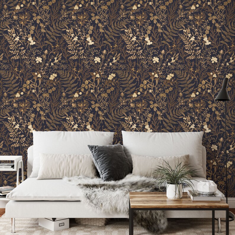 May include: A white bed with a white duvet and a brown wooden coffee table in front of it. The wall behind the bed is covered in a dark blue wallpaper with a gold floral pattern.