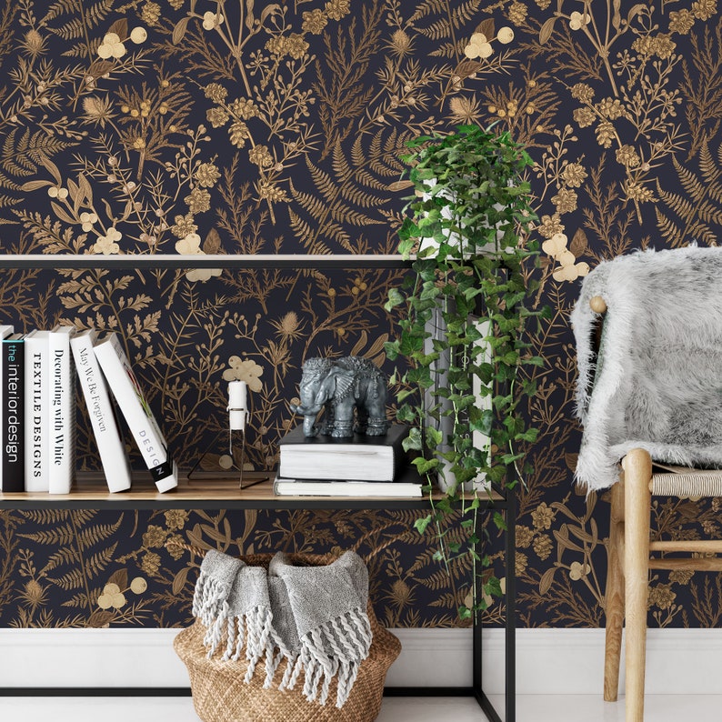 May include: A dark blue wallpaper with a gold floral pattern. The wallpaper features a variety of botanical illustrations, including ferns, leaves, and flowers. The wallpaper is displayed in a room with a shelf, a plant, and a chair.