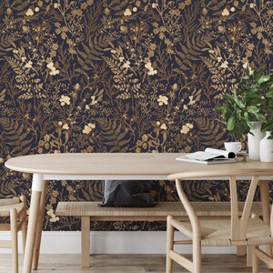 May include: A dining room with dark blue wallpaper featuring a gold floral pattern. The wallpaper has a repeating pattern of leaves, flowers, and berries. The room is decorated with a wooden table, two chairs, and a bench.