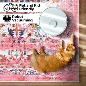 Puede incluir: Una aspiradora robot blanca est&aacute; sobre una alfombra rosa estampada, junto a un gato jengibre. La alfombra tiene un aspecto envejecido y vintage con dise&ntilde;os florales y geom&eacute;tricos. El texto dice "Pet and Kid Friendly" y "Robot Vacuuming".