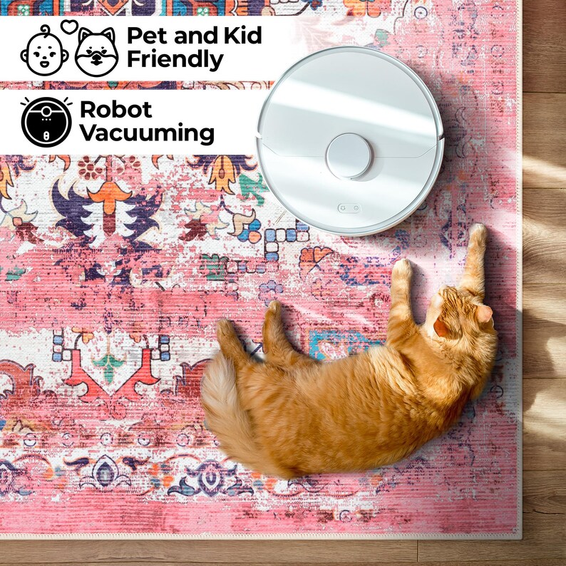 Puede incluir: Una aspiradora robot blanca est&aacute; sobre una alfombra rosa estampada, junto a un gato jengibre. La alfombra tiene un aspecto envejecido y vintage con dise&ntilde;os florales y geom&eacute;tricos. El texto dice "Pet and Kid Friendly" y "Robot Vacuuming".