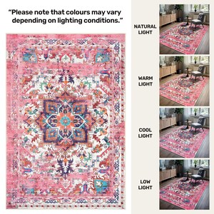 Puede incluir: Una alfombra rectangular rosa con un dise&ntilde;o central de medall&oacute;n en tonos azules, naranjas y blancos. La alfombra presenta un patr&oacute;n ornamentado y desgastado, mostrado bajo diferentes condiciones de iluminaci&oacute;n. El texto dice: "Tenga en cuenta que los colores pueden variar seg&uacute;n las condiciones de iluminaci&oacute;n."