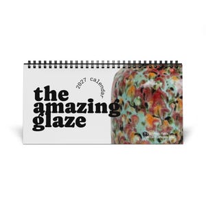 May include: A 2027 spiral-bound wall calendar titled The Amazing Glaze. The left side features bold black text on a white background, while the right side displays a colorful ceramic glaze pattern labeled S-2727 Poppy Fields Over CG-716 Pagoda Green.
