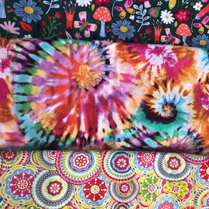 May include: Three fabric swatches with different patterns. The top swatch has a green background with white flowers, red mushrooms, and butterflies. The middle swatch has a tie-dye pattern in shades of pink, orange, blue, and green. The bottom swatch has a white background with colorful circular patterns.