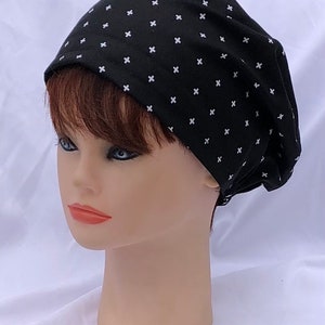 May include: A black beanie with a white cross pattern. The beanie is made of a soft, stretchy fabric and is perfect for keeping your head warm in the winter.