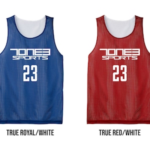 May include: Four reversible basketball jerseys in black, blue, red, and navy, each with white accents. The jerseys feature the text "JONES SPORTS" and the number "23" in white. The bottom of the image displays the color combinations: Black/White, True Royal/White, True Red/White, and True Navy/White.