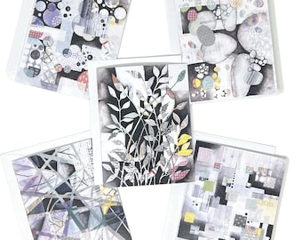 May include: Five greeting cards with abstract art designs. Each card features a unique pattern with geometric shapes, circles, and botanical elements in shades of gray, black, white, and pops of color. The cards are in white envelopes.