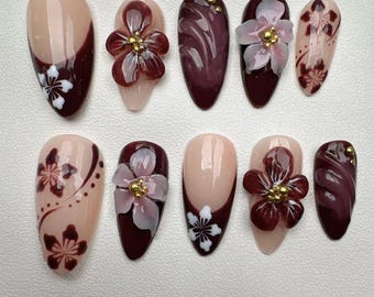 Può includere: Set di dieci unghie finte color borgogna e nude con disegni floreali. Alcune unghie hanno fiori 3D, altre hanno fiori dipinti.