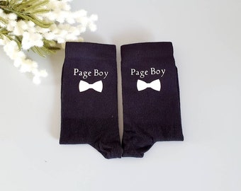 May include: A pair of black socks with white text that reads "Page Boy" and a white bow tie graphic.