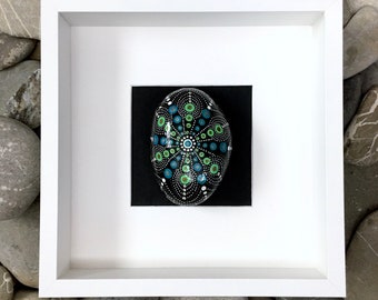 Danza astral - marco y guijarro natural pintado a mano - para posar o colgar - guijarro azul y verde sobre un fondo negro