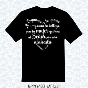 May include: Black t-shirt with white script. The text reads "Enga&ntilde;osa es la gracia y vana la belleza, pero la mujer que teme al Se&ntilde;or, esa ser&aacute; alabada." Proverbs 31:30. The website HAPPYWISEHEART.com is at the bottom.