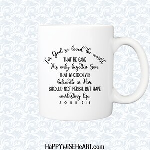 Peut inclure: Tasse en c&eacute;ramique blanche avec une anse incurv&eacute;e. La tasse pr&eacute;sente le texte "For God so loved the world..." en script noir, faisant r&eacute;f&eacute;rence &agrave; Jean 3:16. Le site Web "HAPPYWISEHEART.com" est en bas.