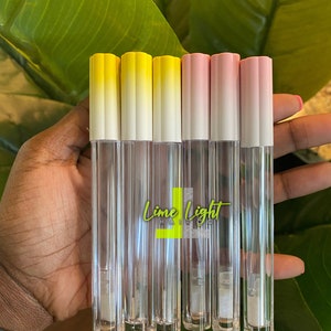 May include: Six clear lip gloss tubes with yellow and pink ombre lids. The tubes are labelled "Lime Light Hair Co."