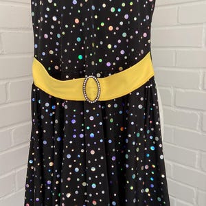 May include: A white ceramic mug with a black handle and the text "But First, Coffee" in a bold, black font. The mug is set against a blurred background, suggesting a cozy setting.