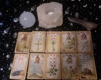 May include: A tarot card reading spread with ten cards laid out on a black background with white stars. The cards are from a vintage deck with ornate borders and illustrations. The cards show the numbers 5, 6, 2, 13, 15, 17, 36, 33, 22, and 30.