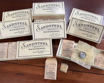 Vintage Boxes of Sandsteel Mainsprings in the w/ 10 tiny envelopes of springs in vintage glassine from the 1920's