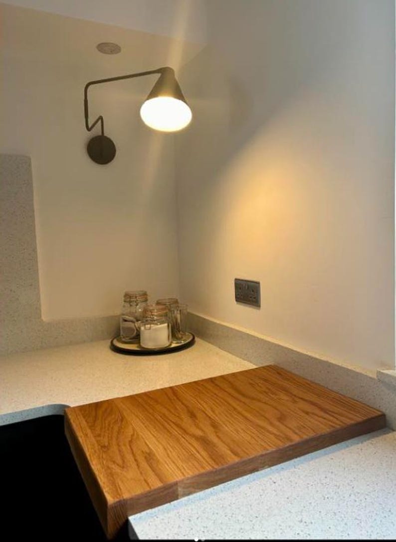 Large wooden sink cover chopping board made of natural oak grain, styled in a modern kitchen setting.