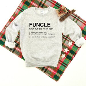 May include: A gray sweatshirt with the word "FUNCLE" defined as "Like a dad...except cool." and "a.k.a. The man, the myth, the legend."  The definition also includes "see also: devilishly handsome, exceptional."