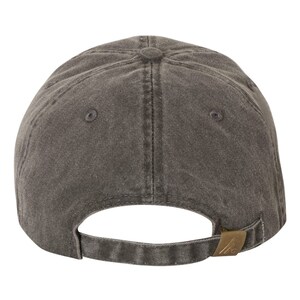 May include: A dark gray baseball cap with a curved brim and adjustable strap. The cap has a classic six-panel design with a button on top and a metal clasp closure. The fabric appears to be a soft, washed cotton.