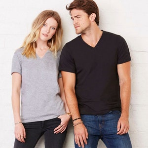 May include: Two people wearing V-neck t-shirts. The person on the left is wearing a heather grey t-shirt and the person on the right is wearing a black t-shirt.