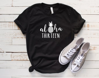 May include: Black t-shirt with a white pineapple and the text "Aloha Thirteen" printed on it.