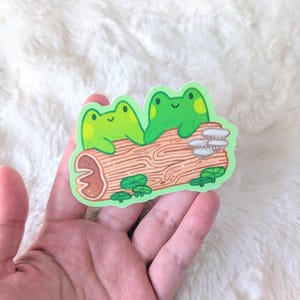 Grenouilles amoureuses - Grenouilles tenant une bûche par la main - Stickers vinyle imperméables Kawaii