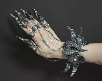 May include: A silver claw ring set with pearl accents and a matching silver winged bracelet with pearl accents.