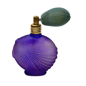 May include: A vintage perfume bottle with a round, frosted purple glass body. The bottle features a gold-colored metal collar and a matching sprayer. A green, woven bulb is attached to the sprayer. The bottle has an Art Deco design.