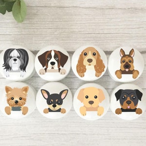 May include: Eight round ceramic knobs featuring various dog breeds peeking over the top. The knobs are white with black outlines and arranged in two rows of four.