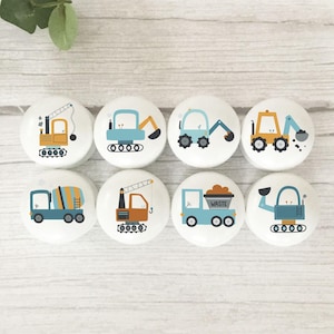 May include: Set of eight round wooden knobs with colourful illustrations of construction vehicles. The knobs feature a crane, excavator, dumper truck, cement mixer, and other construction vehicles.