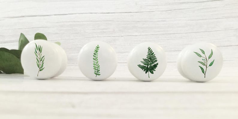 K&ouml;nnte beinhalten: Vier wei&szlig;e Keramikkn&ouml;pfe mit gr&uuml;nen Aquarell-Blattdesigns. Die Designs umfassen einen Farn, einen Zweig mit Bl&auml;ttern und zwei verschiedene Arten von gr&uuml;nen Zweigen.