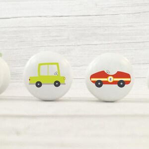 May include: Four ceramic knobs featuring various vehicle designs. A blue submarine, a green car, a red racing car, and an orange tugboat.