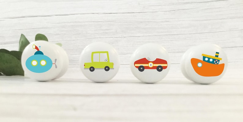 May include: Four ceramic knobs featuring various vehicle designs. A blue submarine, a green car, a red racing car, and an orange tugboat.