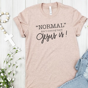 May include: A light pink t-shirt with the text "NORMAL" Ain't coming back Jesus is! printed in black.