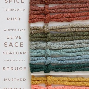 Puede incluir: Una colecci&oacute;n de 14 ovillos de hilo en varios colores, incluyendo salm&oacute;n, almendra, especias, terracota, &oacute;xido, salvia de invierno, oliva, salvia, espuma de mar, azul huevo de pato, abeto, mostaza, coral y negro.