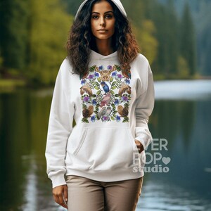 May include: White hooded sweatshirt with a colorful floral and bird design. The design includes owls, bluebirds, and other floral elements. The text "EVER POP studio" is printed on the lower right side of the sweatshirt.