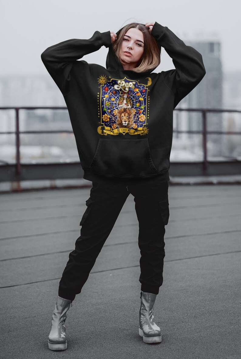 May include: Black hoodie with a graphic print of a lion and the zodiac sign Leo. The graphic features a lion with a crown, stars, and the text "Leo" in gold lettering.