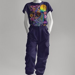 May include: A navy blue t-shirt with a colorful peacock design and floral accents. The peacock is perched on a branch with a yellow moon in the background.